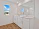 Bright bathroom featuring double sinks, wood-look flooring, and a large window at 1745 Carnelian St, Deland, FL 32720