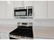 Close-up of modern stainless steel appliances and white cabinets in a bright, updated kitchen at 1745 Carnelian St, Deland, FL 32720