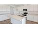 Bright kitchen with white cabinets, quartz countertops, stainless steel appliances, and wood-look flooring at 1745 Carnelian St, Deland, FL 32720