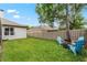 Spacious fenced backyard with lush green grass and a cozy fire pit area with Adirondack chairs at 3852 Brantley Place Cir, Apopka, FL 32703