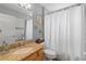 Cozy bathroom features a shower with a white curtain, granite countertop and decorative wall art at 3852 Brantley Place Cir, Apopka, FL 32703