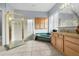 Bathroom with a glass enclosed shower, garden tub, granite countertops, and wooden cabinets at 3852 Brantley Place Cir, Apopka, FL 32703