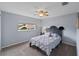 Carpeted bedroom with ceiling fan, window, black headboard and cozy neutral decor at 3852 Brantley Place Cir, Apopka, FL 32703