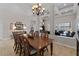Open-concept dining room with decorative chandelier, coffered ceilings, and wooden dining table at 3852 Brantley Place Cir, Apopka, FL 32703