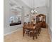 Open-concept dining area with coffered ceilings, a chandelier, tile flooring, and decorative columns at 3852 Brantley Place Cir, Apopka, FL 32703