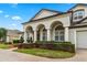 Charming stucco home featuring an arched entryway, attached garage, and well-maintained landscaping at 3852 Brantley Place Cir, Apopka, FL 32703