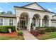 Charming two-story home featuring an arched entryway, manicured landscaping, and elegant architectural details at 3852 Brantley Place Cir, Apopka, FL 32703
