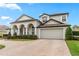 Two-story home with a two-car garage, arched entryway, and manicured landscaping at 3852 Brantley Place Cir, Apopka, FL 32703