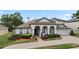 Charming stucco home featuring an arched entryway, attached garage, and well-maintained landscaping at 3852 Brantley Place Cir, Apopka, FL 32703