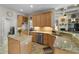 Open-concept kitchen featuring granite countertops and stainless-steel appliances, adjacent to laundry room at 3852 Brantley Place Cir, Apopka, FL 32703