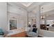 Open-concept living area with hardwood flooring, statement chandelier, and elegant columns at 3852 Brantley Place Cir, Apopka, FL 32703