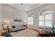 A bright living room featuring large arched windows, hardwood floors, stylish furniture, and neutral decor at 3852 Brantley Place Cir, Apopka, FL 32703