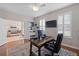 Office with wooden desk, ceiling fan, a large TV, a view of the living room, and many windows at 3852 Brantley Place Cir, Apopka, FL 32703