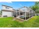 Backyard with a screened in pool, patio, and lush green lawn at 3852 Brantley Place Cir, Apopka, FL 32703