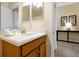 Well-lit bathroom featuring a vanity with wood cabinets, a large mirror, and tile flooring at 8904 Candy Palm Rd, Kissimmee, FL 34747