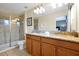 Bathroom featuring double vanity with granite countertop and a glass door shower at 8904 Candy Palm Rd, Kissimmee, FL 34747