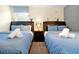 Bedroom with two beds, each with blue bedding and bedside table at 8904 Candy Palm Rd, Kissimmee, FL 34747