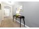 Inviting hallway featuring neutral carpet and paint, plus a stylish table with decor at 8904 Candy Palm Rd, Kissimmee, FL 34747