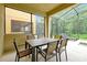 Screened lanai with a table, seating, and a view of the backyard and pool at 8904 Candy Palm Rd, Kissimmee, FL 34747