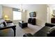 Relaxing living room with dark sofas, carpeted floor, modern lighting, and entertainment center at 8904 Candy Palm Rd, Kissimmee, FL 34747