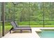 Inviting screened pool area with comfortable lounge chairs overlooking a lush green backdrop at 8904 Candy Palm Rd, Kissimmee, FL 34747