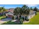 A beautiful single-story home with palm trees and a brick driveway at 1005 Salamanca Pl, Davenport, FL 33837