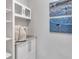 Functional laundry room provides storage with upper cabinets and built-in shelving for organization at 1005 Salamanca Pl, Davenport, FL 33837