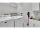 Bright laundry room with white washer, dryer, shelves, sink and storage at 1005 Salamanca Pl, Davenport, FL 33837