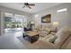 Inviting living room features comfortable seating, a ceiling fan, and sliding glass doors leading to the lanai at 1005 Salamanca Pl, Davenport, FL 33837