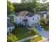 Aerial view of a charming two-story home featuring lush landscaping, a driveway, and a well-manicured lawn at 1039 Tourmaline Dr, Kissimmee, FL 34746