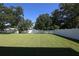 Large, expansive backyard with a manicured lawn and bordered by a white fence, offering privacy and space at 1039 Tourmaline Dr, Kissimmee, FL 34746