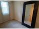 Bedroom with carpet, a window with blinds, and a large mirror leaning against the wall at 1039 Tourmaline Dr, Kissimmee, FL 34746