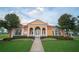 Attractive clubhouse with a terracotta roof, arched entryway, and manicured landscaping creates a welcoming community gathering space at 1039 Tourmaline Dr, Kissimmee, FL 34746
