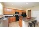 This open kitchen features wood cabinetry, black appliances, and an island with stool seating at 1039 Tourmaline Dr, Kissimmee, FL 34746