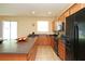 Bright kitchen features an island, black appliances, tile flooring and wood cabinets at 1039 Tourmaline Dr, Kissimmee, FL 34746