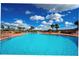 Community pool surrounded by lush landscaping and lounge chairs at 1039 Tourmaline Dr, Kissimmee, FL 34746