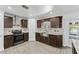 Modern kitchen featuring dark wood cabinets, stone countertops, and stainless steel appliances at 1067 Ronlin St, Haines City, FL 33844