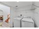 Efficient laundry room with washer, dryer, and shelving for optimal storage and organization at 1067 Ronlin St, Haines City, FL 33844