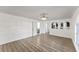 Spacious living room with bright lighting, wood-look flooring, and arched openings to the kitchen at 1067 Ronlin St, Haines City, FL 33844