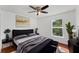 Comfortable main bedroom with a ceiling fan, a dark bed frame, and a bright window at 1067 Ronlin St, Haines City, FL 33844