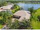 Aerial view of a landscaped home near a lake, featuring mature trees and meticulous landscaping at 107 Belzano Pl, Poinciana, FL 34759