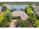 Aerial view of a landscaped home near a lake, featuring mature trees and meticulous landscaping at 107 Belzano Pl, Poinciana, FL 34759
