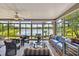 Bright sunroom with panoramic lake views, tile flooring, and comfortable seating arrangement at 107 Belzano Pl, Poinciana, FL 34759