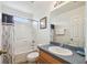 Cozy bathroom with shower-tub combination, oak vanity, granite countertop and decorative curtain at 1119 Mariner Cay Dr, Haines City, FL 33844