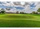 Expansive golf course with meticulously manicured green and bunkers under a sunny sky at 1119 Mariner Cay Dr, Haines City, FL 33844