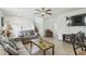 Bright living room featuring a comfortable couch, ceiling fan, wood-look floors, and a television at 1119 Mariner Cay Dr, Haines City, FL 33844