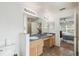 Bathroom featuring double sinks, a large mirror, tile floors and a view to the main bedroom at 1119 Mariner Cay Dr, Haines City, FL 33844