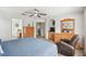 Comfortable main bedroom with ceiling fan, wood dresser, recliner, and a view to the main bathroom at 1119 Mariner Cay Dr, Haines City, FL 33844