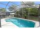 Sparkling screened-in pool with in-pool seating and a view of the lush backyard at 1119 Mariner Cay Dr, Haines City, FL 33844