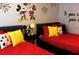 Whimsical bedroom featuring two beds with colorful Mickey Mouse-themed decor and playful wall art at 1122 Spaceport Ct, Kissimmee, FL 34741